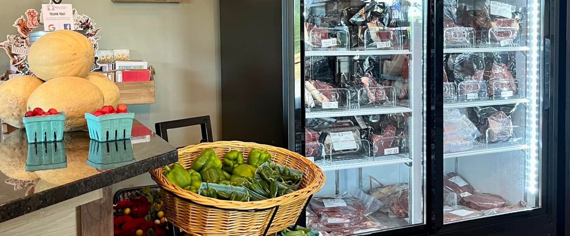 Photo of cooler of meats and fresh vegetable table in the store