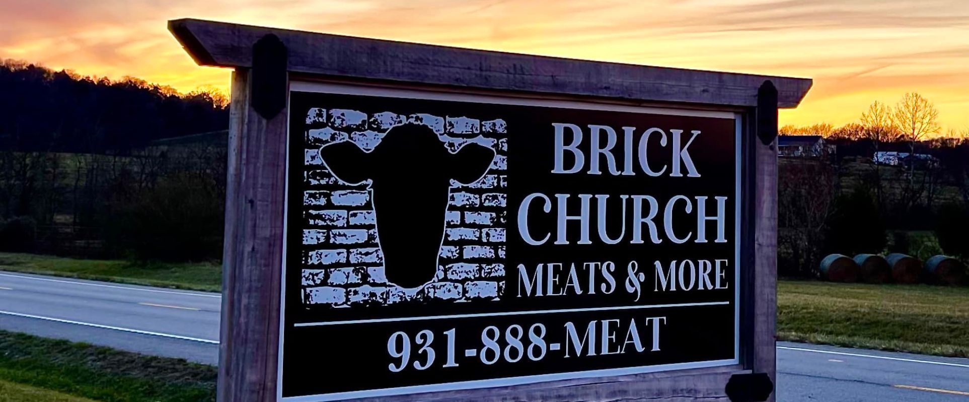 Photo of Brick Church Meats and More 931 888 Meat sign on the roadway at dusk